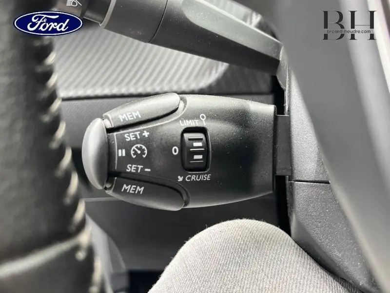 Le véhicule visible n'est pas une Peugeot 208 mais une Ford, le détail montre la commande de régulateur de vitesse au volant côté gauche.