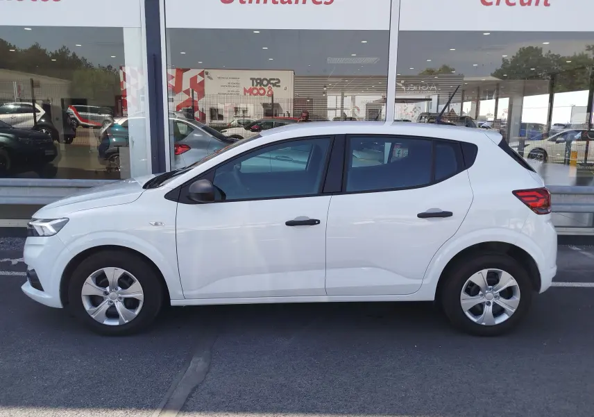 Vue de profil côté gauche d'une Dacia Sandero blanche Glacier 2025, avec jantes alliage et rétroviseurs noirs.