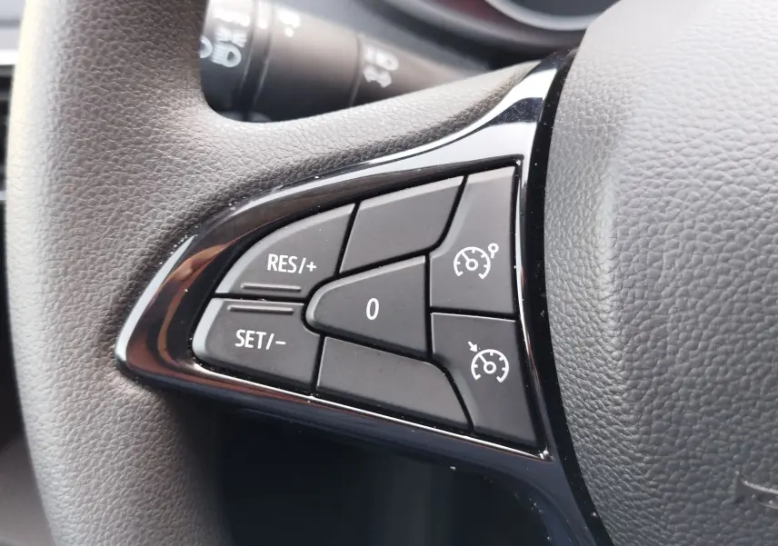 Gros plan sur les commandes de régulateur de vitesse au volant du Dacia Sandero 2025, finition Essentiel.