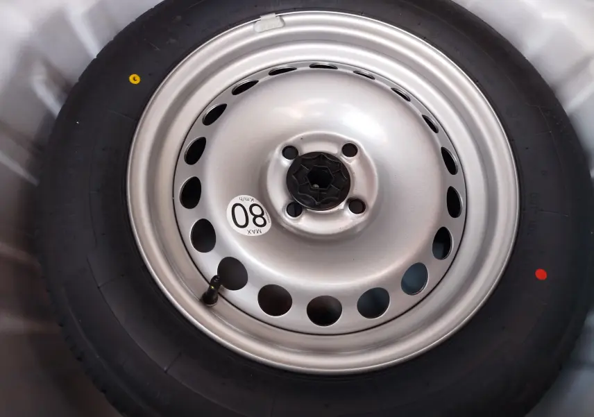 Gros plan sur la roue de secours en acier gris argenté du Dacia Sandero Blanc Glacier 2025, avec étiquette de vitesse 80 km/h.