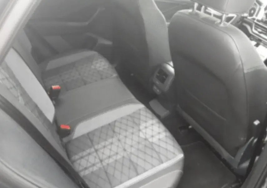 Vue intérieure arrière côté droit du Volkswagen T-Roc 2025, sièges tissu noir et gris avec surpiqûres croisées.