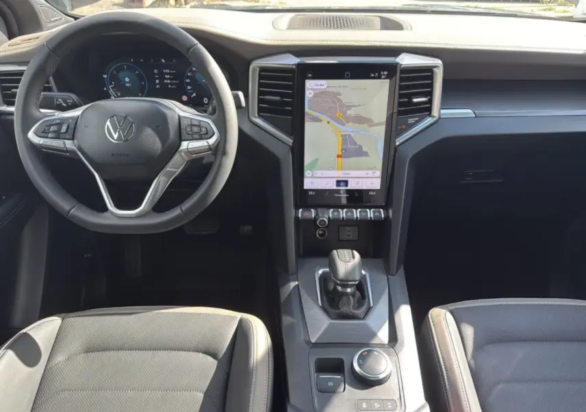 Intérieur du Volkswagen Amarok Simple Cabine 2025 en vue frontale, avec écran tactile central et volant multifonction noir.