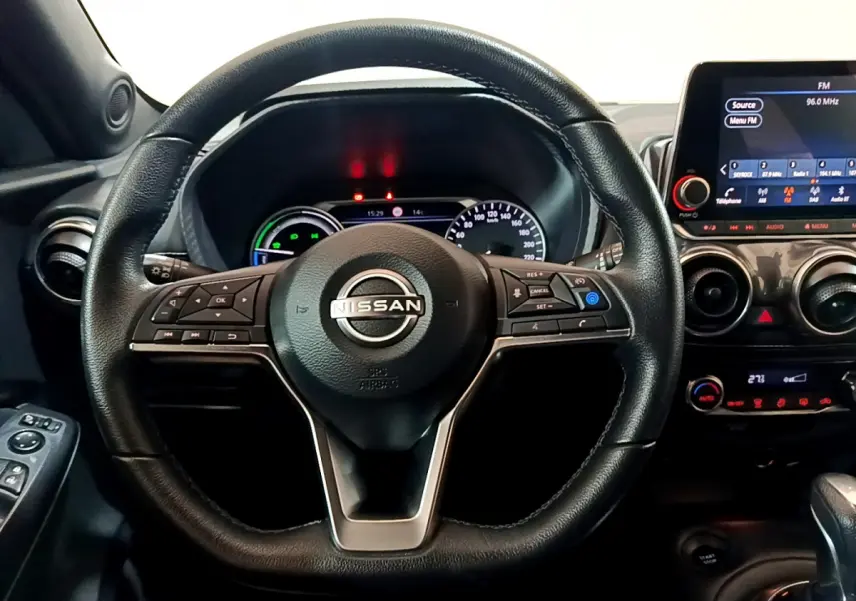 Vue rapprochée du volant cuir noir Nissan Juke Hybrid 143 Business+ 2023 avec tableau de bord et écran tactile.