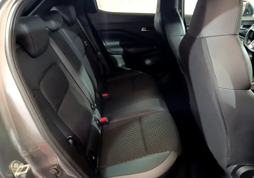 Vue intérieure sur la banquette arrière noire du Nissan Juke Hybrid 143 Business+ gris foncé, avec sièges tissu et cuir.