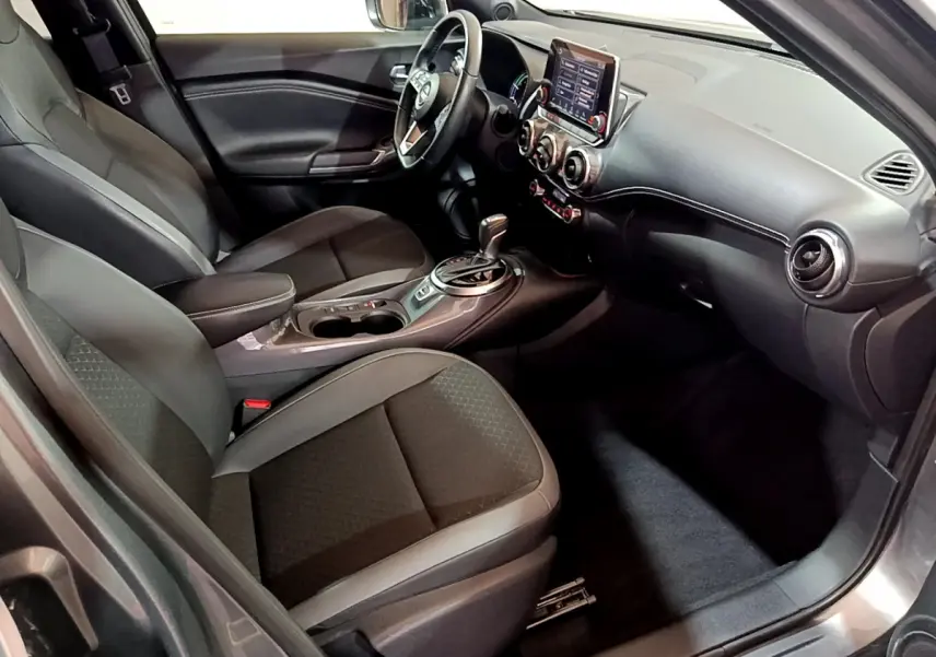 Intérieur avant droit du Nissan Juke Hybrid 143 Business+ 2023 avec sièges noirs et tableau de bord moderne.