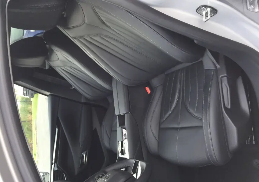 Vue intérieure côté conducteur du DS4 2024 avec sièges en cuir noir et console centrale moderne.