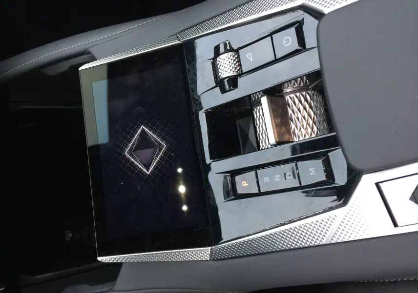 Gros plan sur la console centrale du DS4 2024 avec commandes de boîte auto et écran tactile au design texturé.