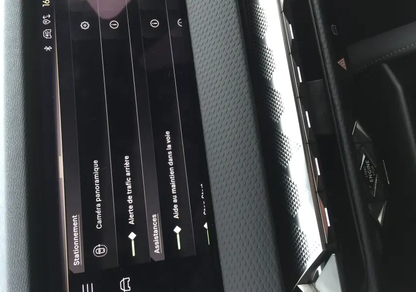 Détail de l'écran tactile central du DS4 2024 montrant les options d'assistance à la conduite, avec tableau de bord noir texturé.