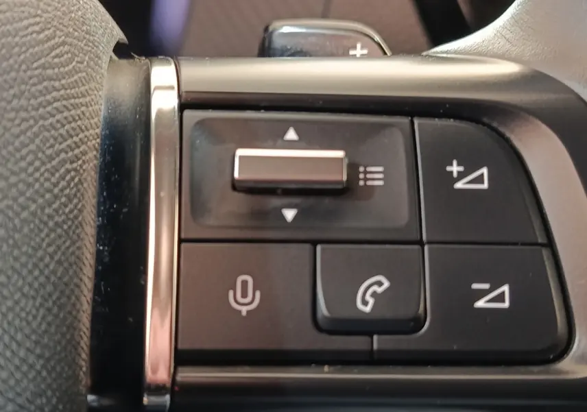 Gros plan sur les commandes vocales et téléphone au volant cuir noir de la Citroën C4 gris foncé 2022.