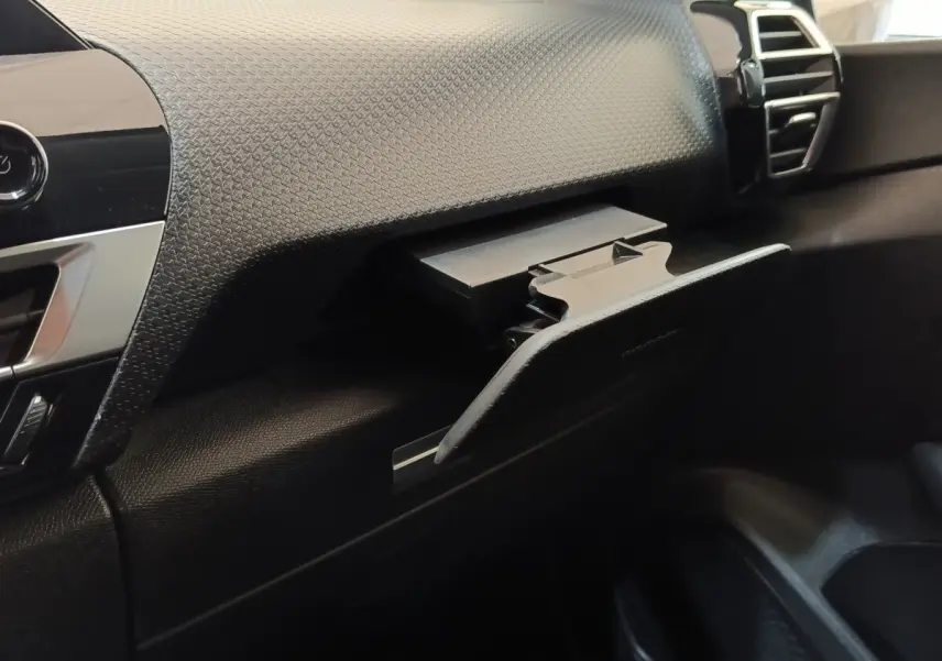 Intérieur côté passager du Citroën C4 2022, détail de la boîte à gants ouverte avec tableau de bord texturé noir.