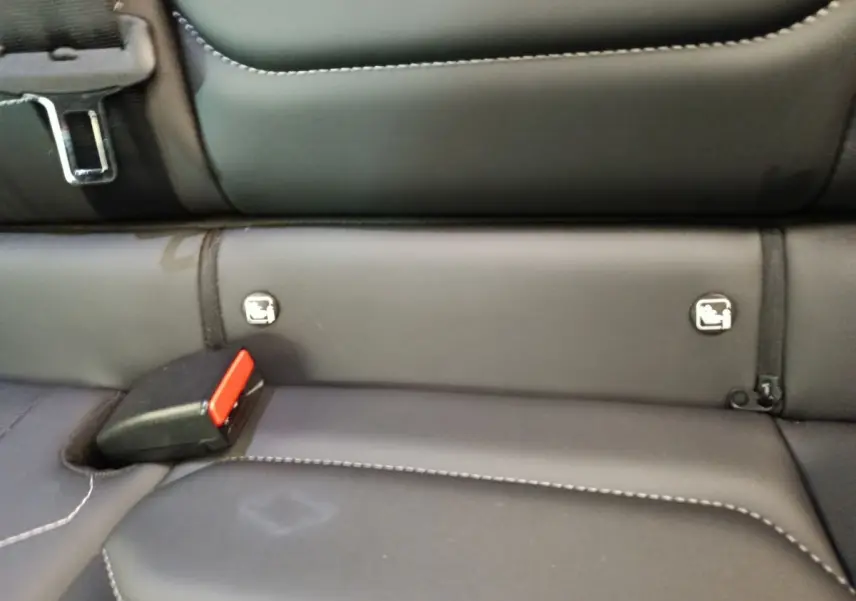 Détail de la banquette arrière noire avec ceintures et fixations Isofix visibles dans une Citroën C4 gris foncé.