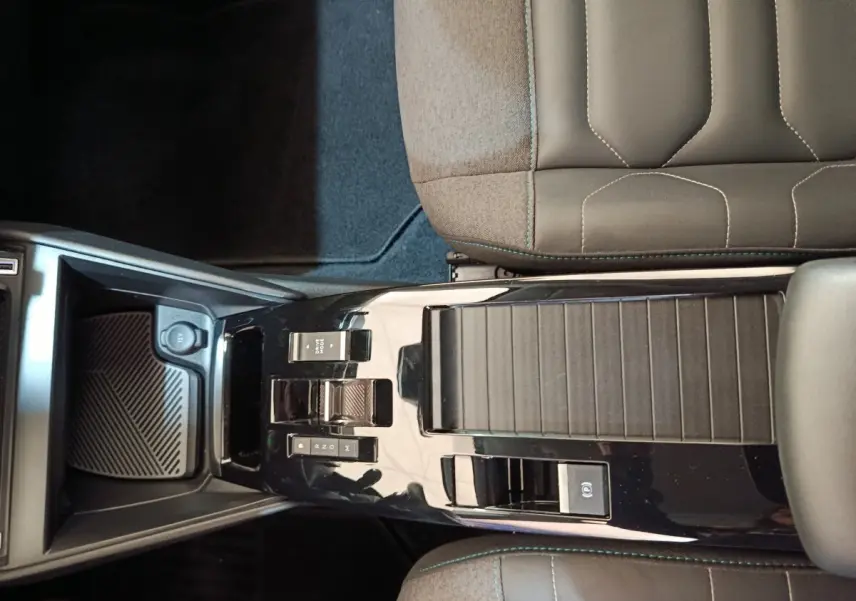 Vue plongeante sur la console centrale noire brillante et les sièges gris foncé de la Citroën C4 2022.