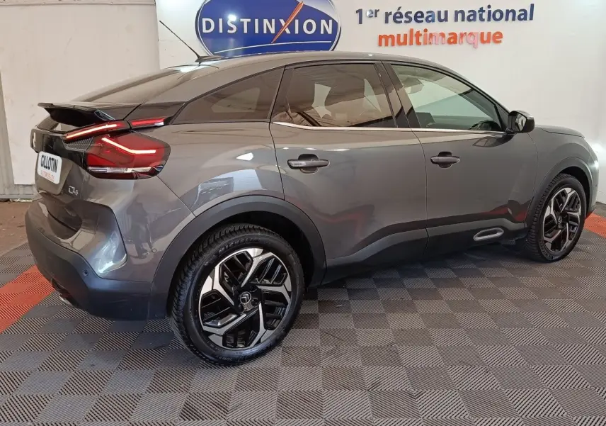 Vue côté droit arrière d'une Citroën C4 gris foncé 2022 avec feux arrière LED et jantes alliage bicolores.