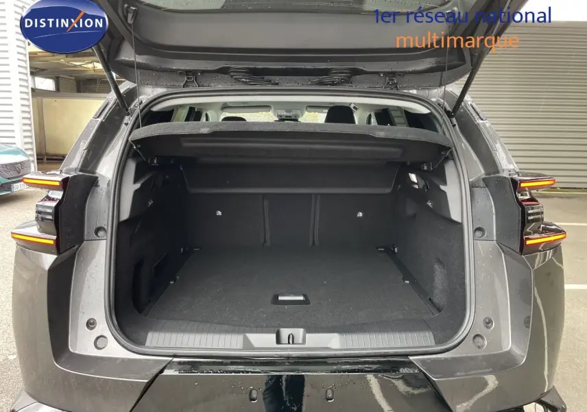 Vue arrière du coffre ouvert d'un Citroën C5 Aircross Hybrid gris platinium métal, avec feux arrière allumés.