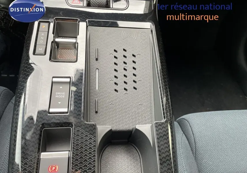 Vue rapprochée de la console centrale noire brillante du Citroën C5 Aircross Hybrid 2026 avec commandes de boîte auto et espace de rangement.
