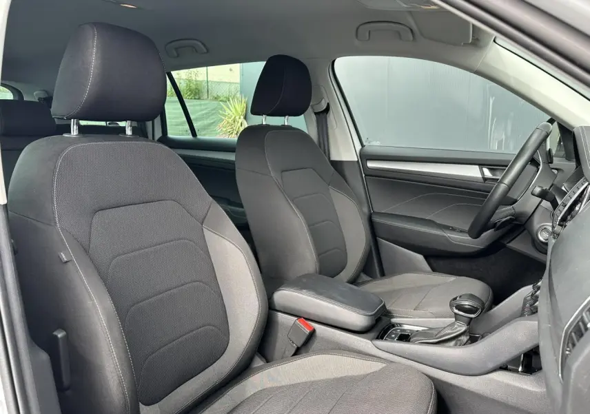 Intérieur avant du Skoda Kodiaq 2024, vue côté droit montrant sièges tissu gris et console centrale avec boîte auto.