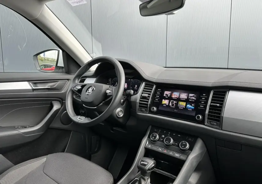 Vue intérieure côté conducteur du Skoda Kodiaq blanc Glacier 2024, avec tableau de bord digital et écran tactile central.