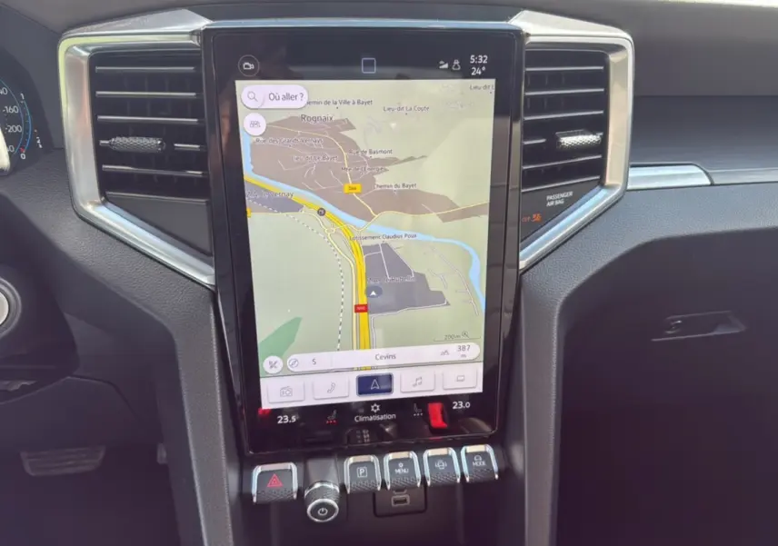 Vue rapprochée de l’écran tactile central du Volkswagen Amarok 2025 gris foncé avec navigation affichée et commandes sous l’écran.