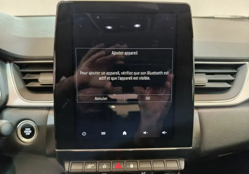 Écran tactile central allumé avec message Bluetooth sur tableau de bord noir du Renault Captur gris foncé 2024