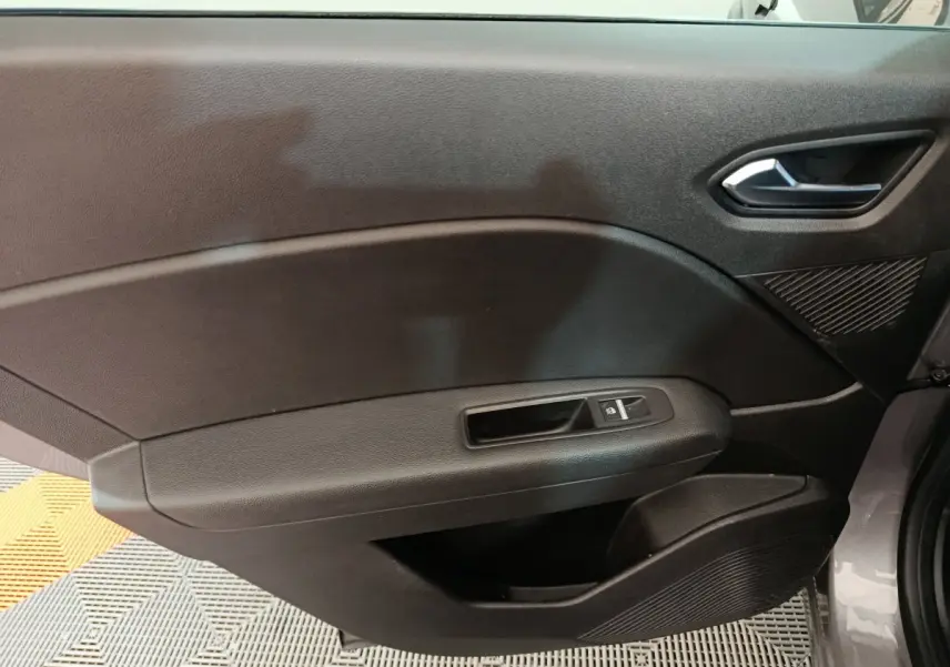 Panneau de porte intérieur côté gauche noir du Renault Captur techno TCe 90 gris foncé 2024 avec commande de fenêtre électrique.