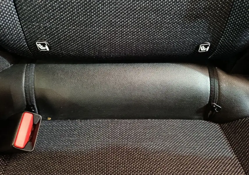 Gros plan sur la banquette arrière noire du Renault Captur 2024 avec attaches Isofix visibles et ceinture rouge.