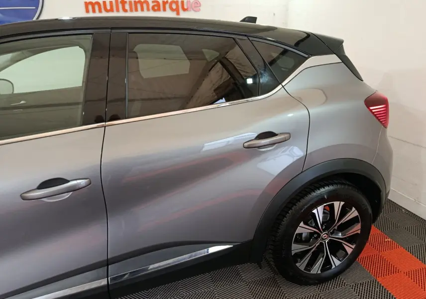 Profil droit du Renault Captur Techno TCe 90 gris foncé, mettant en valeur les jantes alliage et les poignées de porte chromées.
