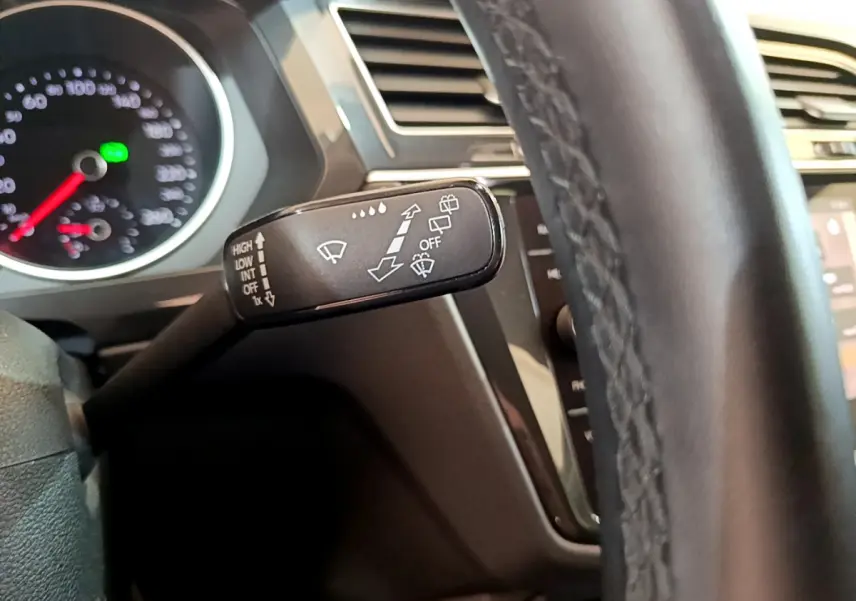 Le levier de commande des essuie-glaces du Volkswagen Tiguan gris clair, vu de près côté gauche du volant en cuir.