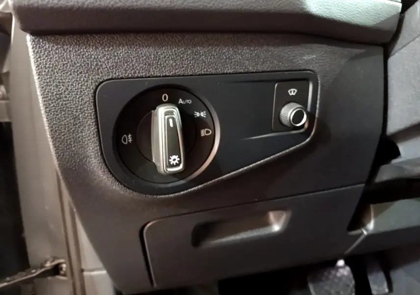 Gros plan sur le panneau de commande des phares à gauche du volant dans le Volkswagen Tiguan gris clair 2021.