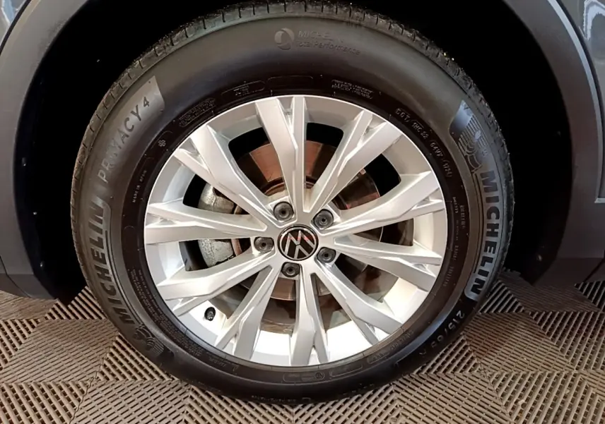 Gros plan sur la roue avant droite du Volkswagen Tiguan gris clair avec jante alliage et pneu Michelin.