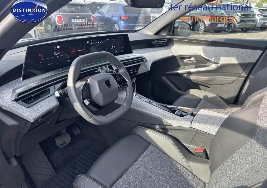 Vue intérieure côté conducteur du Peugeot 3008 2025, tableau de bord moderne avec écran large et sièges bicolores gris et noir.