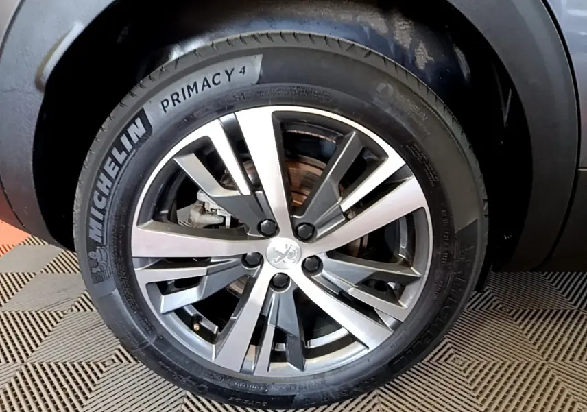 Gros plan sur la roue avant gauche du Peugeot 3008 gris foncé, avec jante alliage et pneu Michelin Primacy 4.