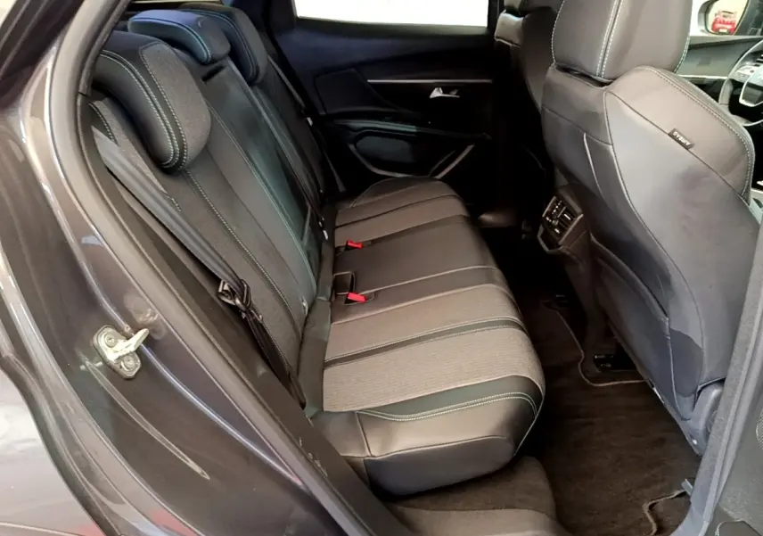 Vue côté gauche de l'intérieur arrière gris foncé du Peugeot 3008 avec sièges en cuir et tissu, et appuie-têtes visibles.