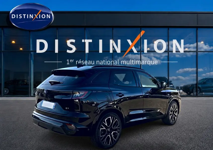 Vue 3/4 arrière droite du Renault Austral noir brillant avec jantes alu et becquet arrière, devant une vitrine Distinxion.