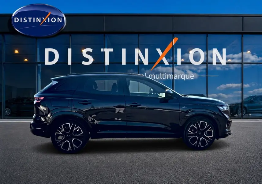 Profil droit du Renault Austral noir 2026 esprit Alpine avec jantes alu distinctives, devant une vitrine multimarque.