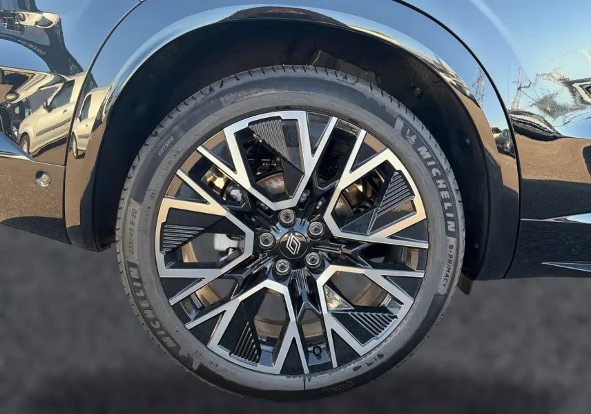Gros plan sur la roue avant droite noire du Renault Austral 1.2 e-tech full hybrid avec jante alu bicolore design moderne.