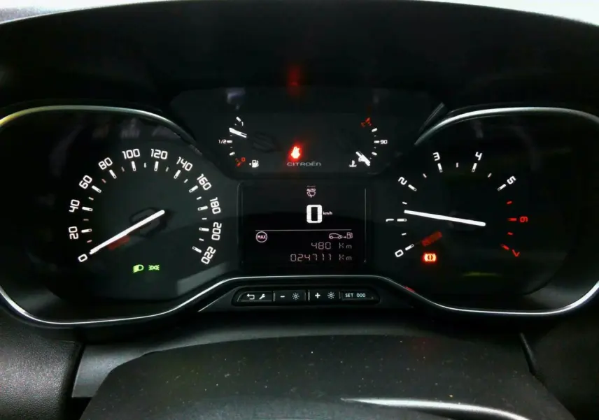 Vue rapprochée du tableau de bord noir du Citroën C3 Aircross 2024 avec compteurs numériques et analogiques allumés.