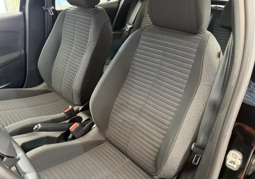Gros plan sur les sièges avant gris foncé de la Peugeot 208 PureTech 100 Active Business, côté conducteur ouvert.