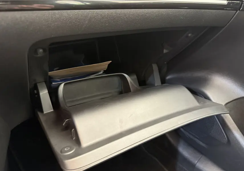 Gant de boîte à gants ouvert côté passager avec documents, intérieur noir de la Peugeot 208 PureTech 2021.