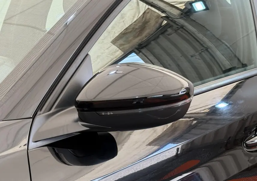 Gros plan sur le rétroviseur côté gauche noir brillant d'une Peugeot 208 PureTech 100 de 2021.