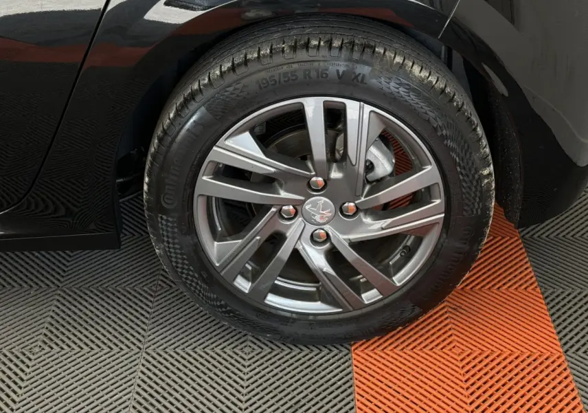 Gros plan sur la roue avant droite noire de la Peugeot 208 2021 avec jante alliage et pneu Continental.