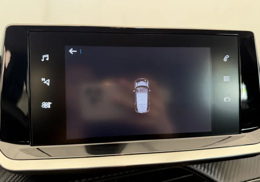 Écran tactile central affichant la vue aérienne du véhicule Peugeot 208 noir, tableau de bord moderne.