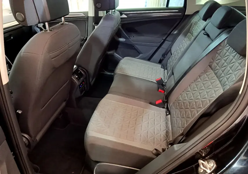 Vue intérieure arrière côté droit du Volkswagen Tiguan 2.0 TDI noir, sièges arrière en tissu gris à motifs géométriques.