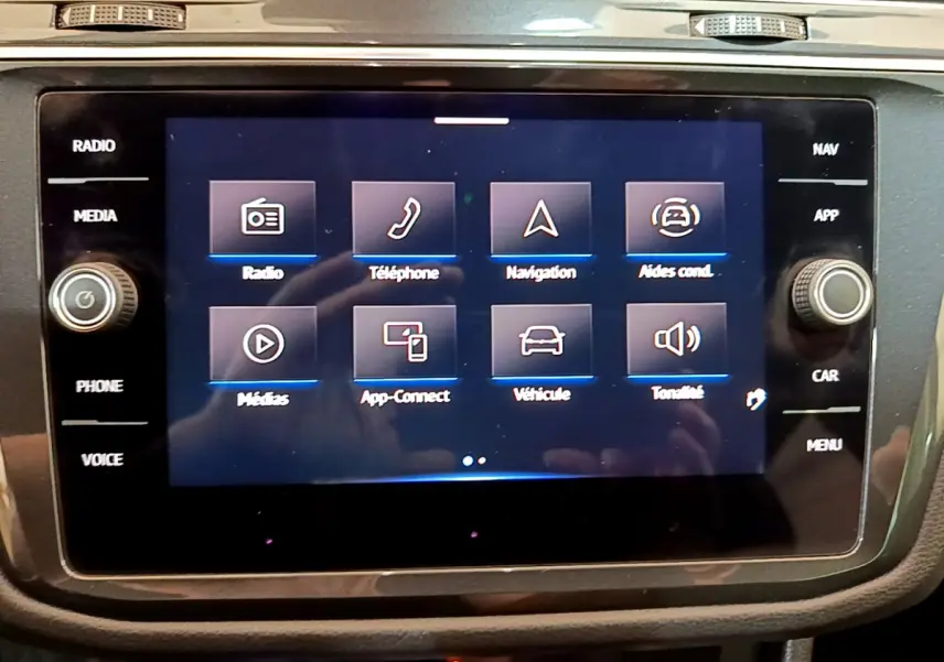 Écran tactile central du tableau de bord du Volkswagen Tiguan 2.0 TDI noir, affichant les options multimédia et navigation.