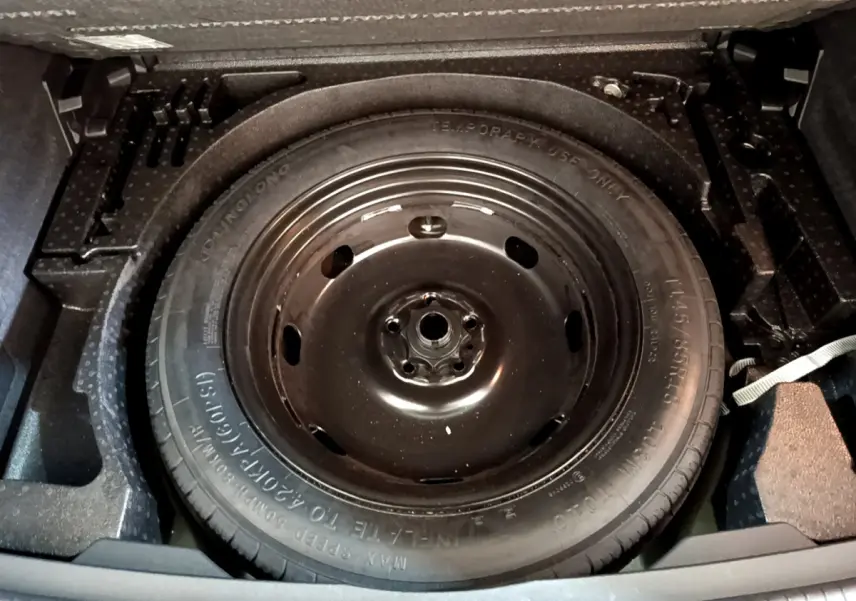 Roue de secours noire en gros plan dans le coffre du Volkswagen Tiguan 2.0 TDI 150 DSG7 Life Business 2021.