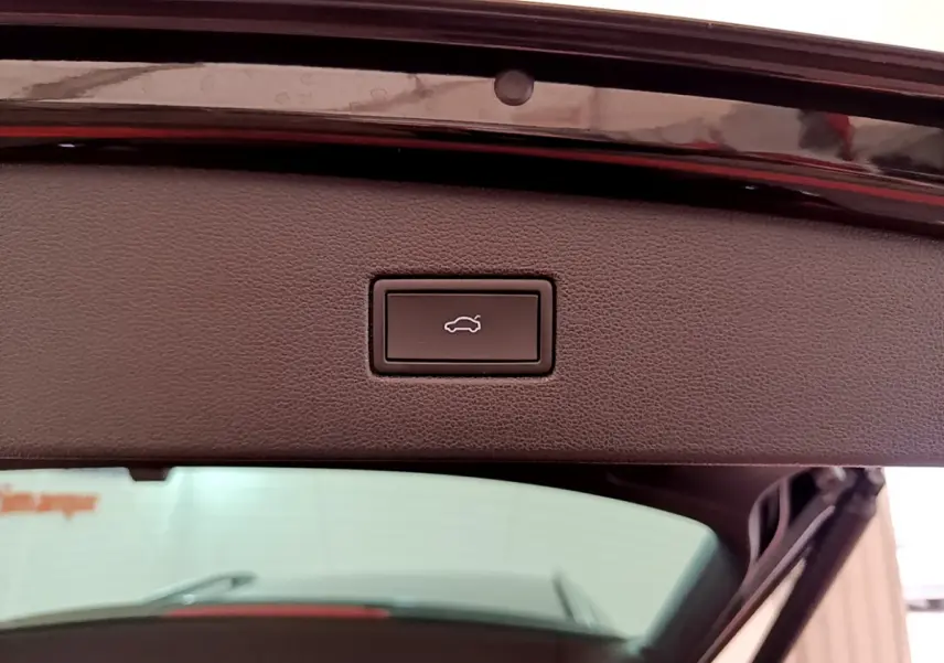 Bouton de fermeture électrique du coffre sur la partie intérieure du hayon d'un Volkswagen Tiguan noir.