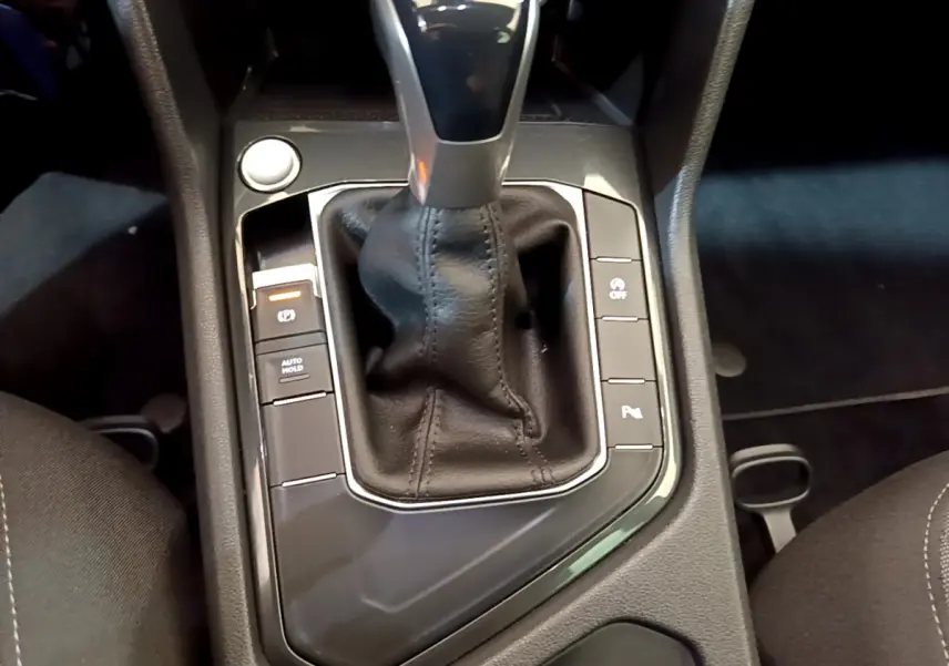 Gros plan sur la console centrale noire du Volkswagen Tiguan 2.0 TDI avec levier de vitesses automatique et boutons fonctionnels.
