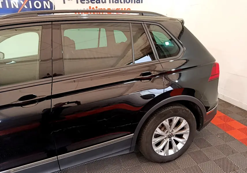 Vue latérale côté gauche d'un Volkswagen Tiguan noir 2.0 TDI 150 DSG7 Life Business avec jantes alliage.