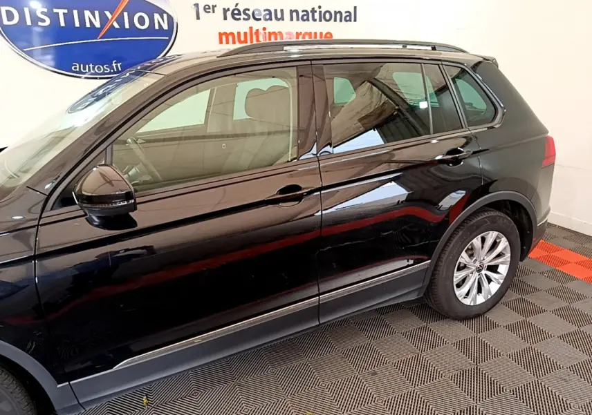 Vue latérale côté gauche d'un Volkswagen Tiguan noir 2021, avec jantes alliage et rétroviseur noir brillant.