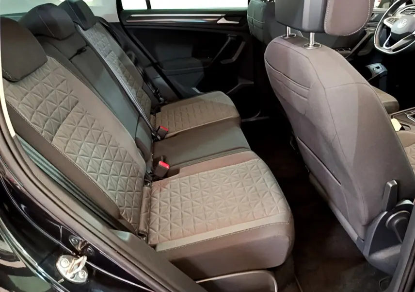 Vue intérieure côté gauche sur la banquette arrière grise au tissu matelassé du Volkswagen Tiguan noir 2021.