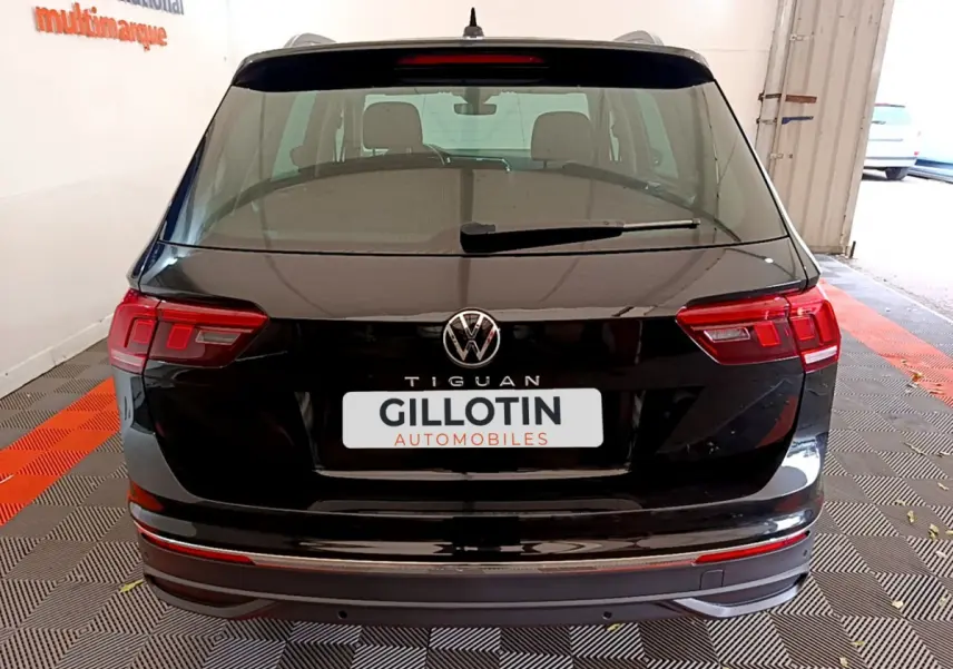 Vue arrière d'un Volkswagen Tiguan noir 2021 avec feux LED et logo VW visible sur le hayon.
